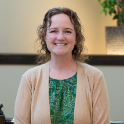 Randi Pando, Human Resources Manager at Cedar Ridge Village, smiling in a professional setting with a plant in the background.